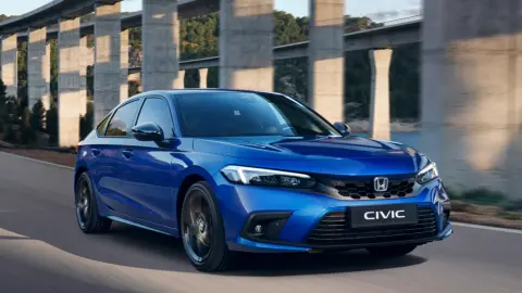 Modrý hybrid Civic jedoucí v horské krajině.