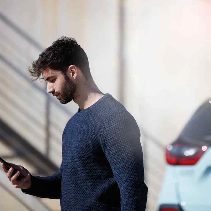 My Honda+ App close up of person using phone outside of car