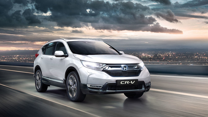Přední tříčtvrtinový pohled na model Honda CR-V s rozsvícenými dálkovými světlomety