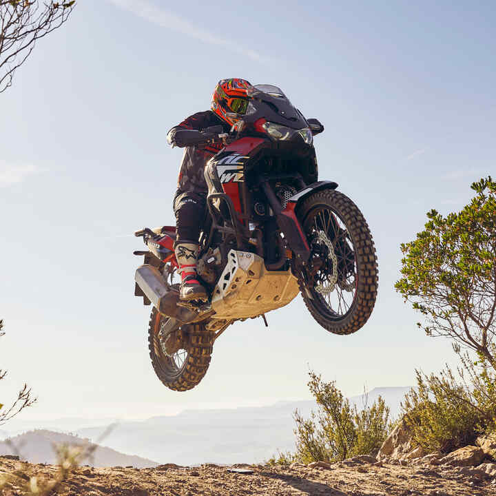 Jezdec na stroji Honda CRF1100L Africa Twin jedoucí po nerovném terénu