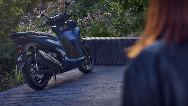 Pohled zezadu na skútr Honda SH350i na zahradě 