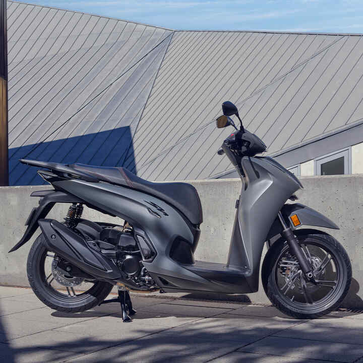 Boční pohled na skútr Honda SH350i stojící na dvoře