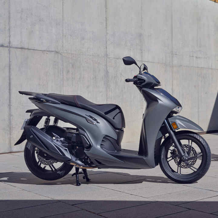 Dva stojící skútry Honda SH350i před budovou 