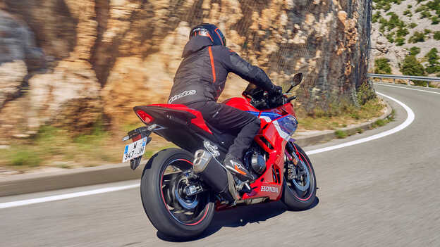 Dynamický zadní tříčtvrtinový pohled na model CBR500R v zatáčce